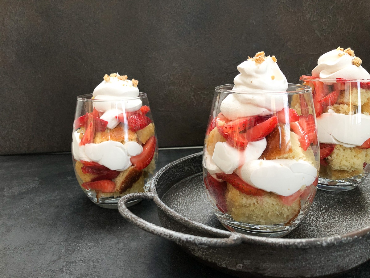 two strawberry parfaits on tray and one not on tray.