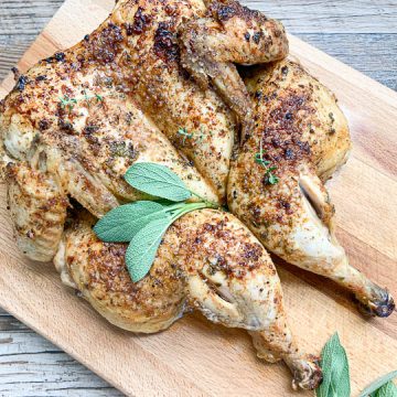 whole roasted chicken on wooden cutting board