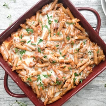 Easy Baked Ziti served in a square burgandy baking dish