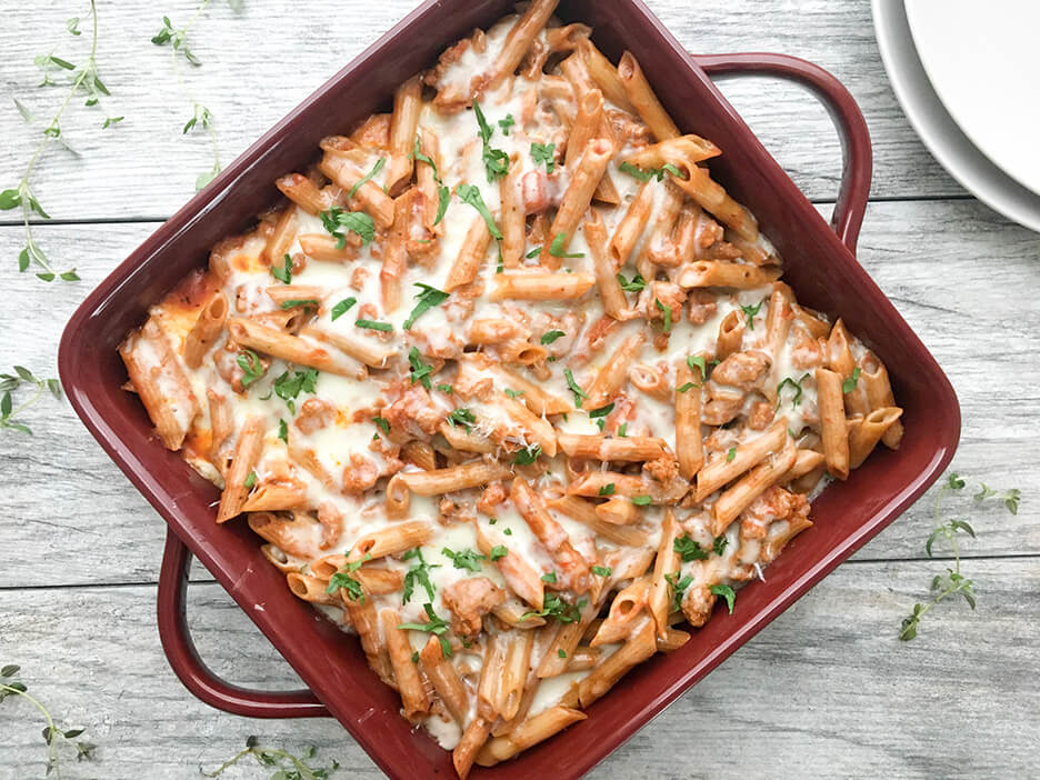 Easy Baked Ziti served in a square burgandy baking dish