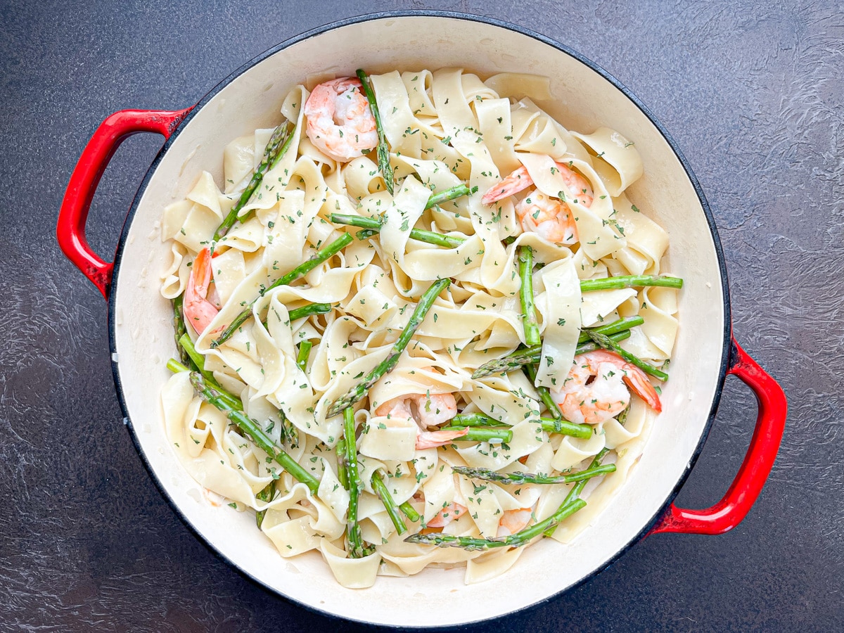 shrimp, asparagus, and pasta added to skillet and coated with unsweetened canned coconut milk.