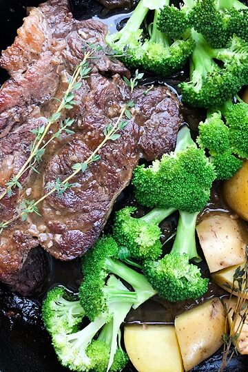 oven baked chuck roast recipe in cast iron skillet with potatoes and broccoli