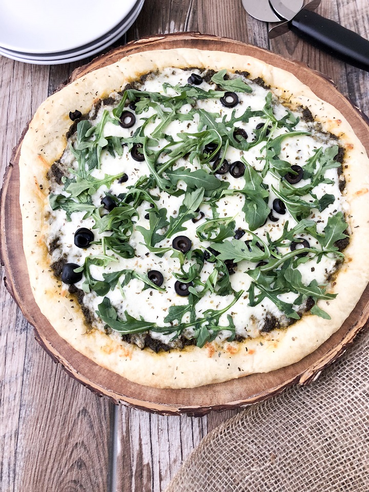 pesto pizza topped with arugula