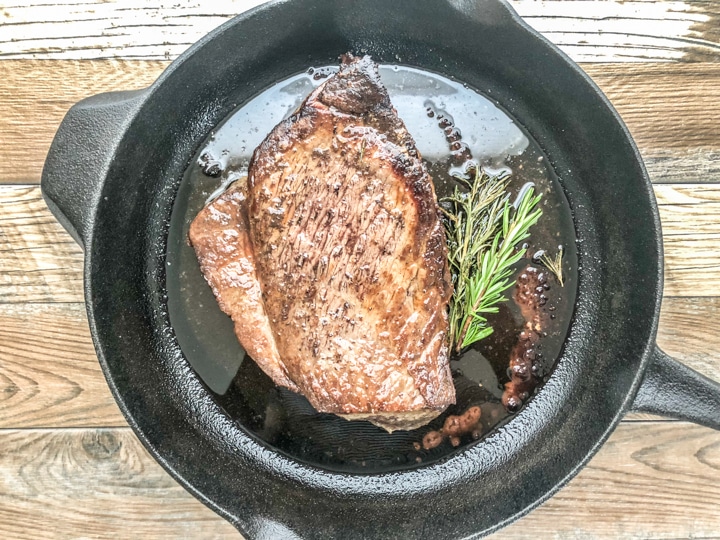 London broil cooking in cast iron skillet.