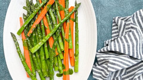 roasted asparagus and carrots on white serving dish.