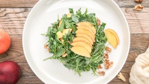 frontal view of simple arugula salad with nectarines