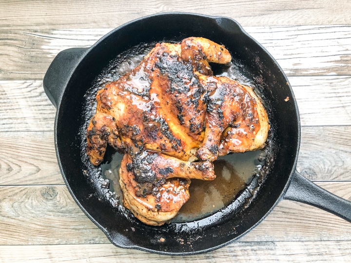 spatchcock chicken in cast iron skillet that's been basted with pan juices