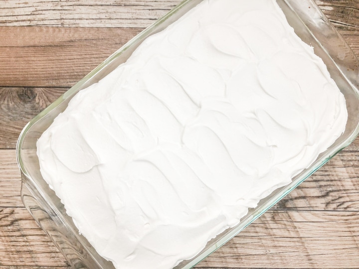 vanilla pudding in glass casserole dish topped with whip cream