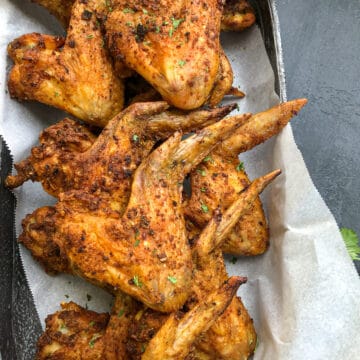 close-up photo of crispy oven baked chicken wings in oval platter.