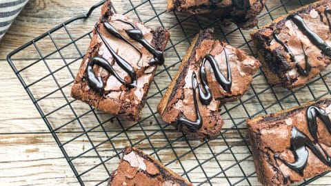 brownie cookie bars on cooling rack drizzled with fudge