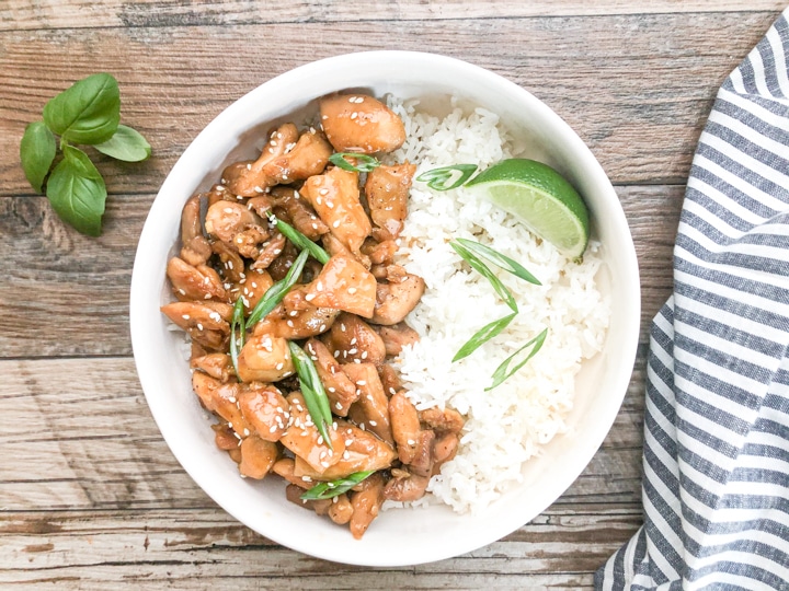 sesame chicken served with white rice in white bowl