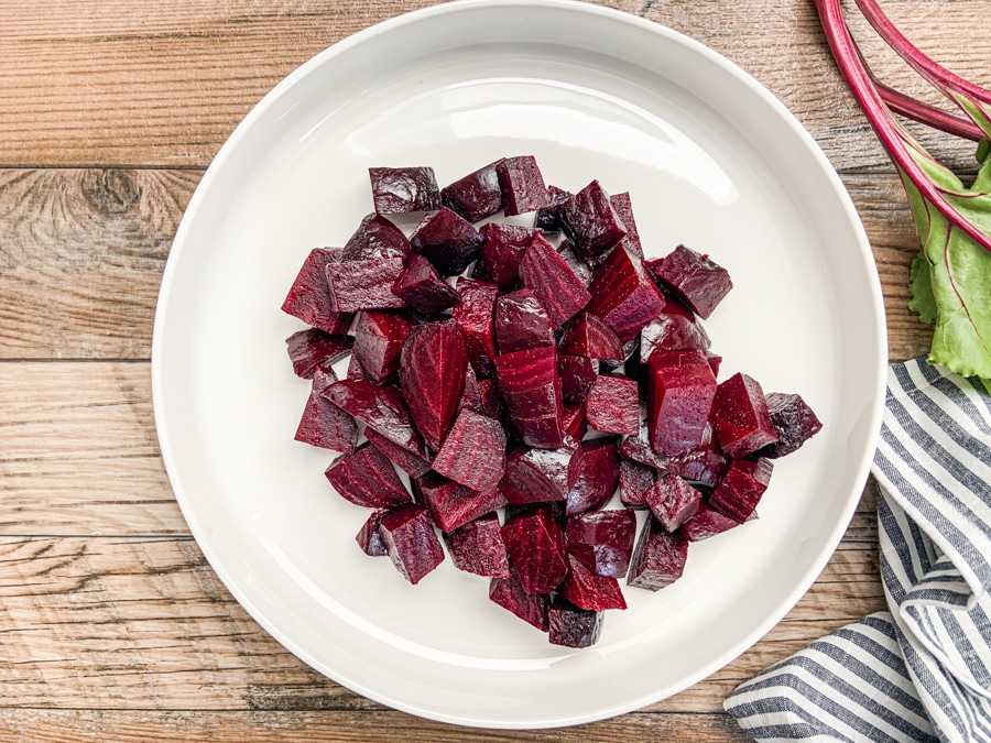 roasted beets cut into chucks on white plate.