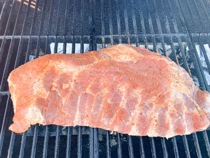 slab of pork spare ribs placed on charcoal grill