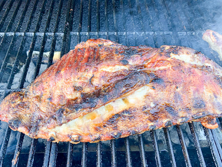 pork spare ribs grilling on outdoor grill