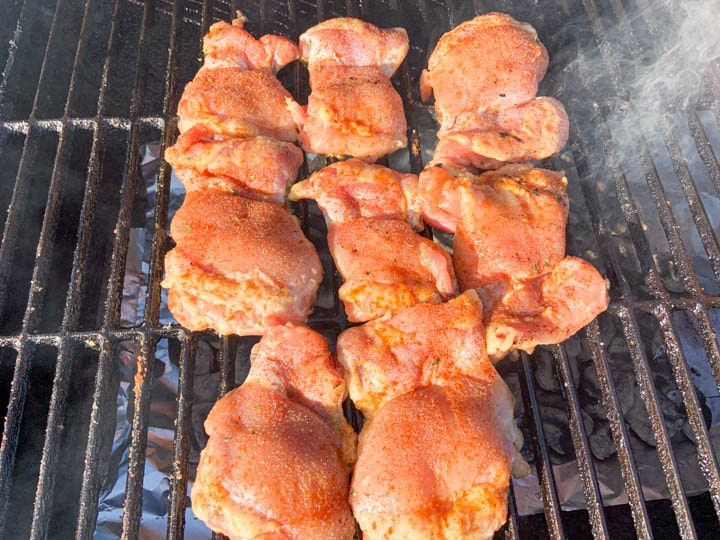 raw chicken thighs on grill grates
