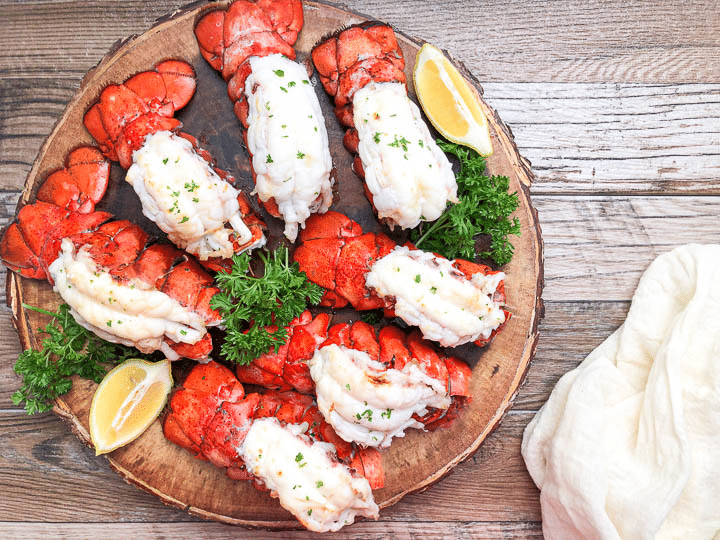 lobster tails on platter next to beige napkin