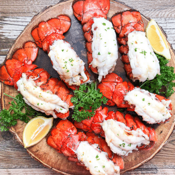 broiled lobster tails on round serving platter garnished with parsley