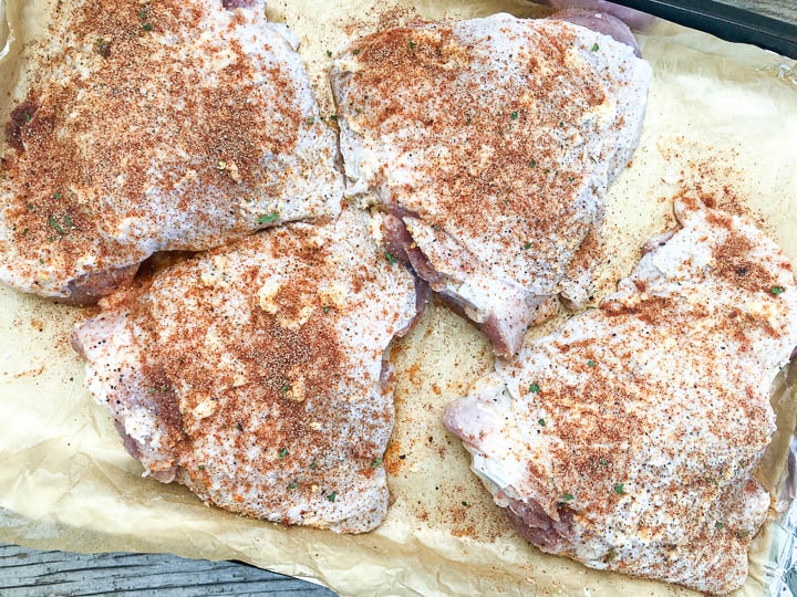 seasoned turkey thighs on parchment paper