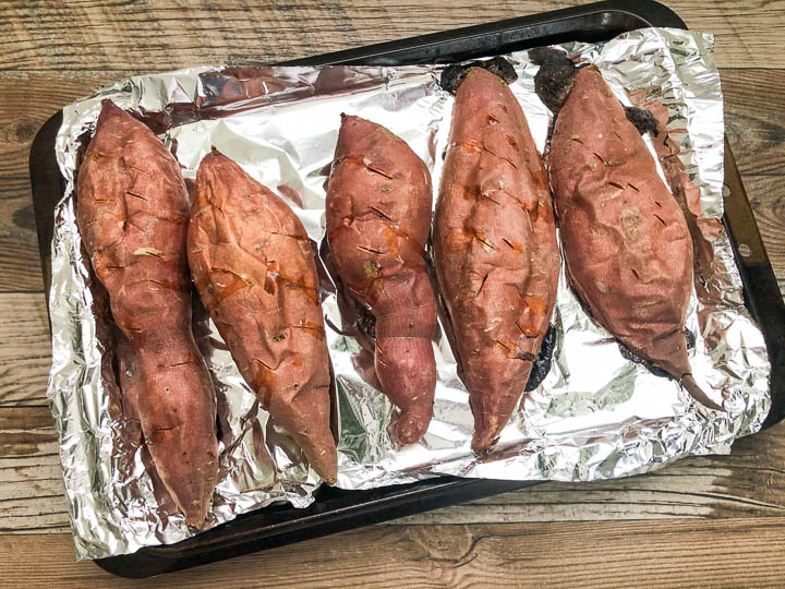 baked yams arranged on baking sheet lined with foil paper