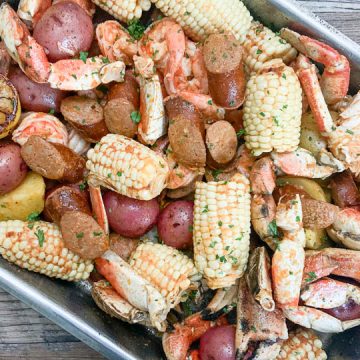 seafood boil in pan garnished with lemon lemon and parsley