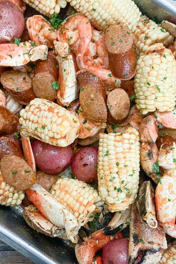 seafood boil in pan garnished with lemon lemon and parsley