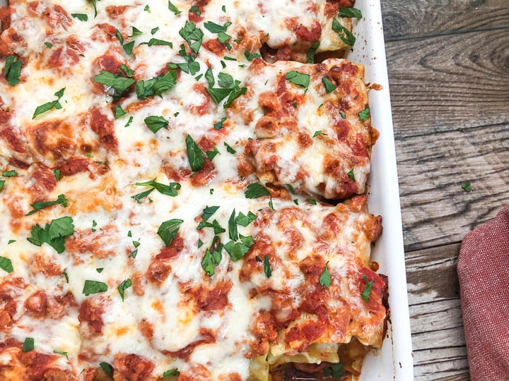 lasagna roll up in white baking dish