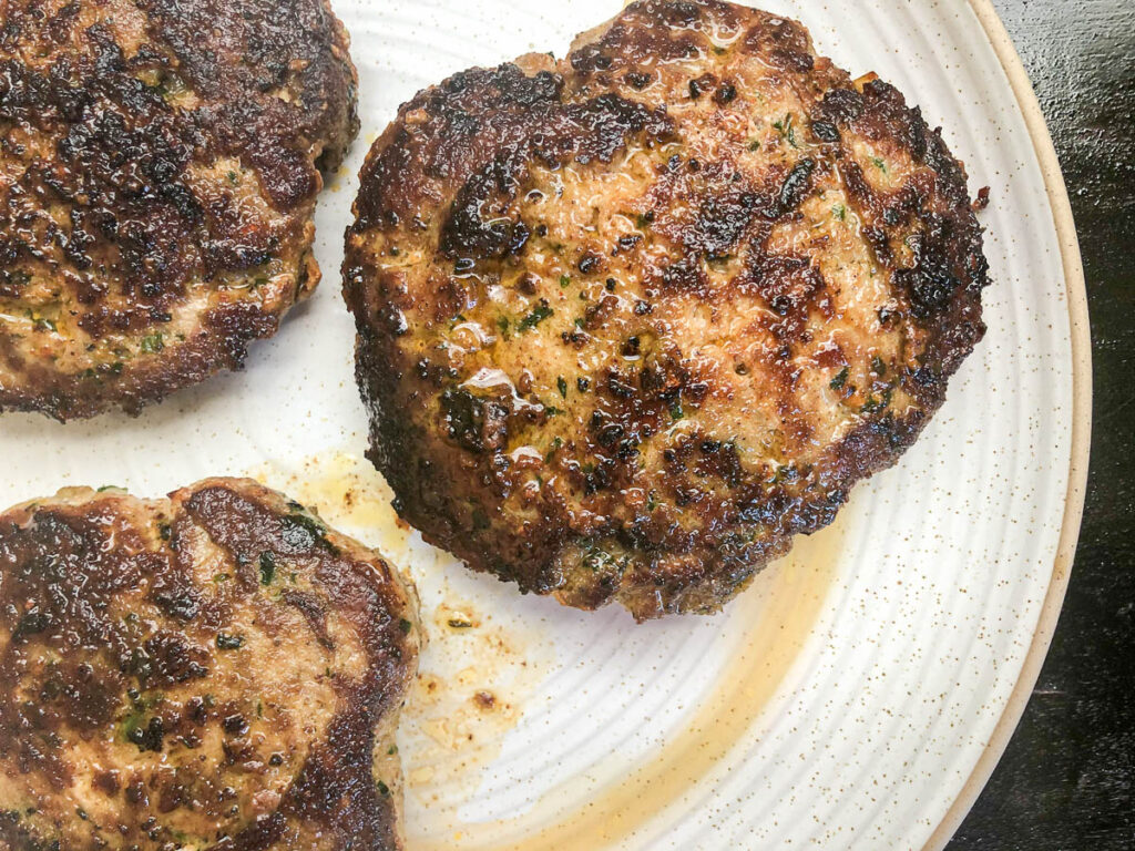 cooked turkey patties on clean white plate