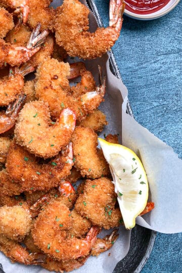 panko fried shrimp in oval platter with dipping sauce.