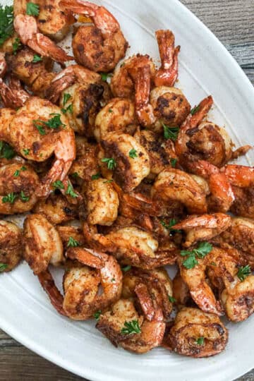 seared shrimp on oval platter garnished with parsley