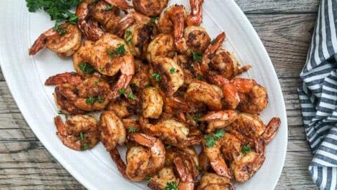 seared shrimp on oval platter garnished with parsley