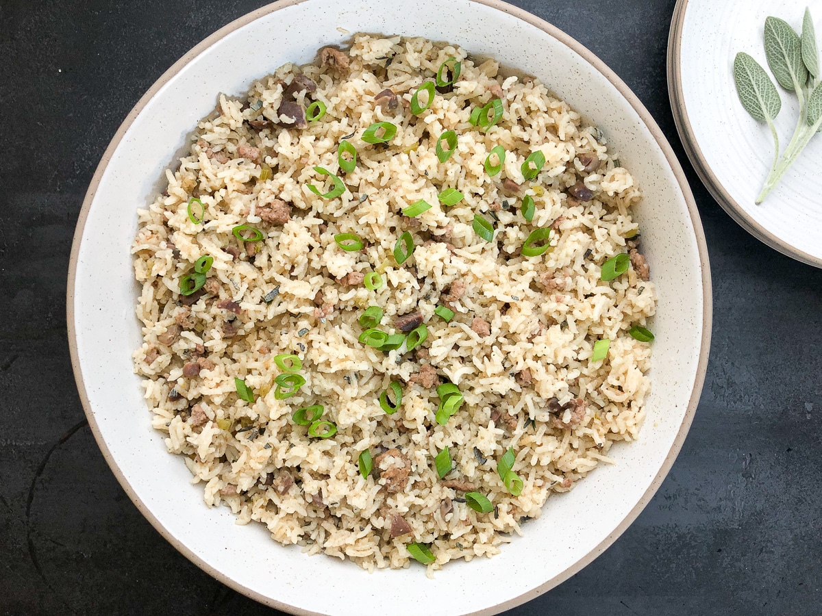 Cajun rice dressing in white bowl with brown trim.