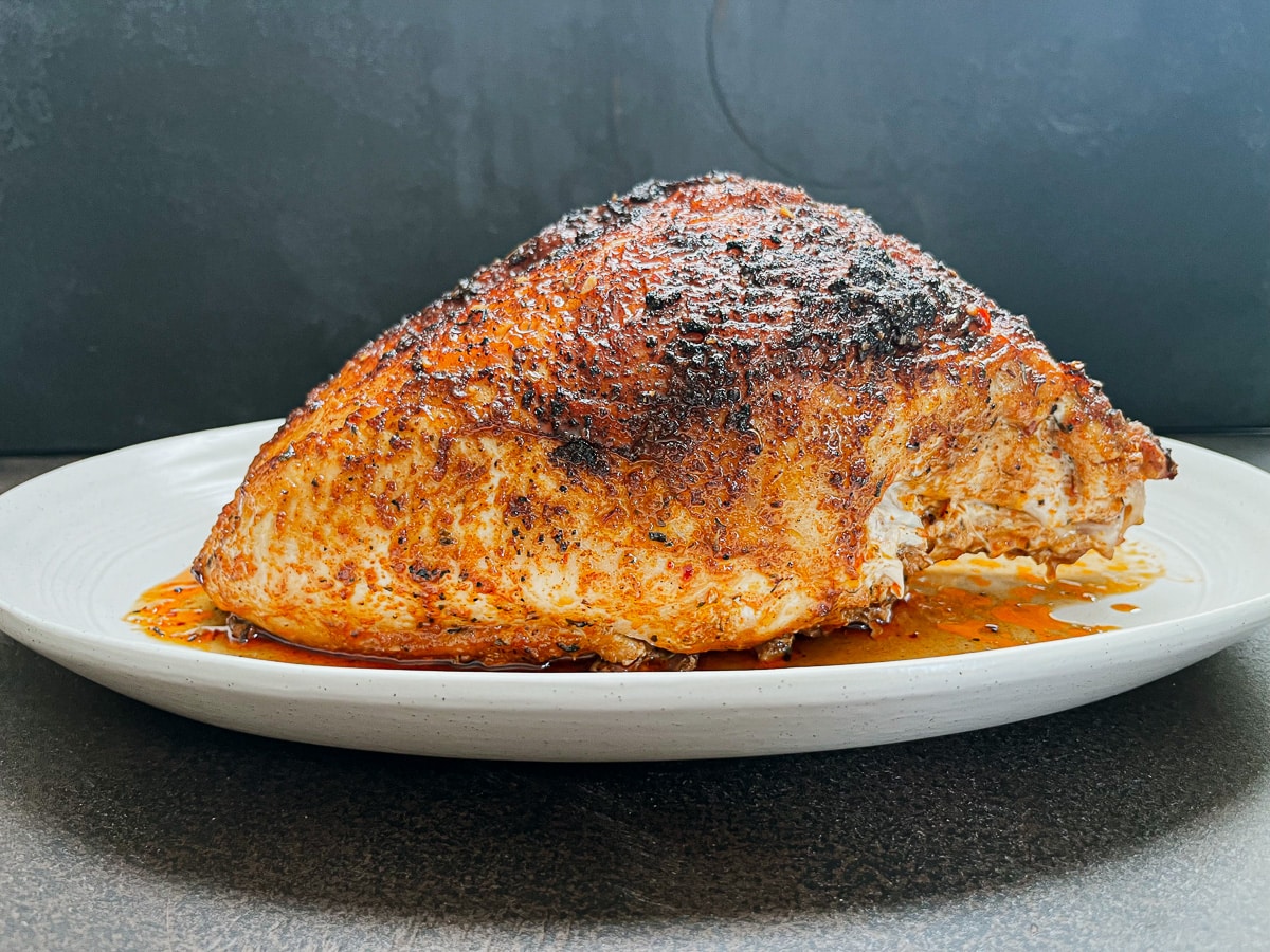 cajun turkey breast on white oval platter.