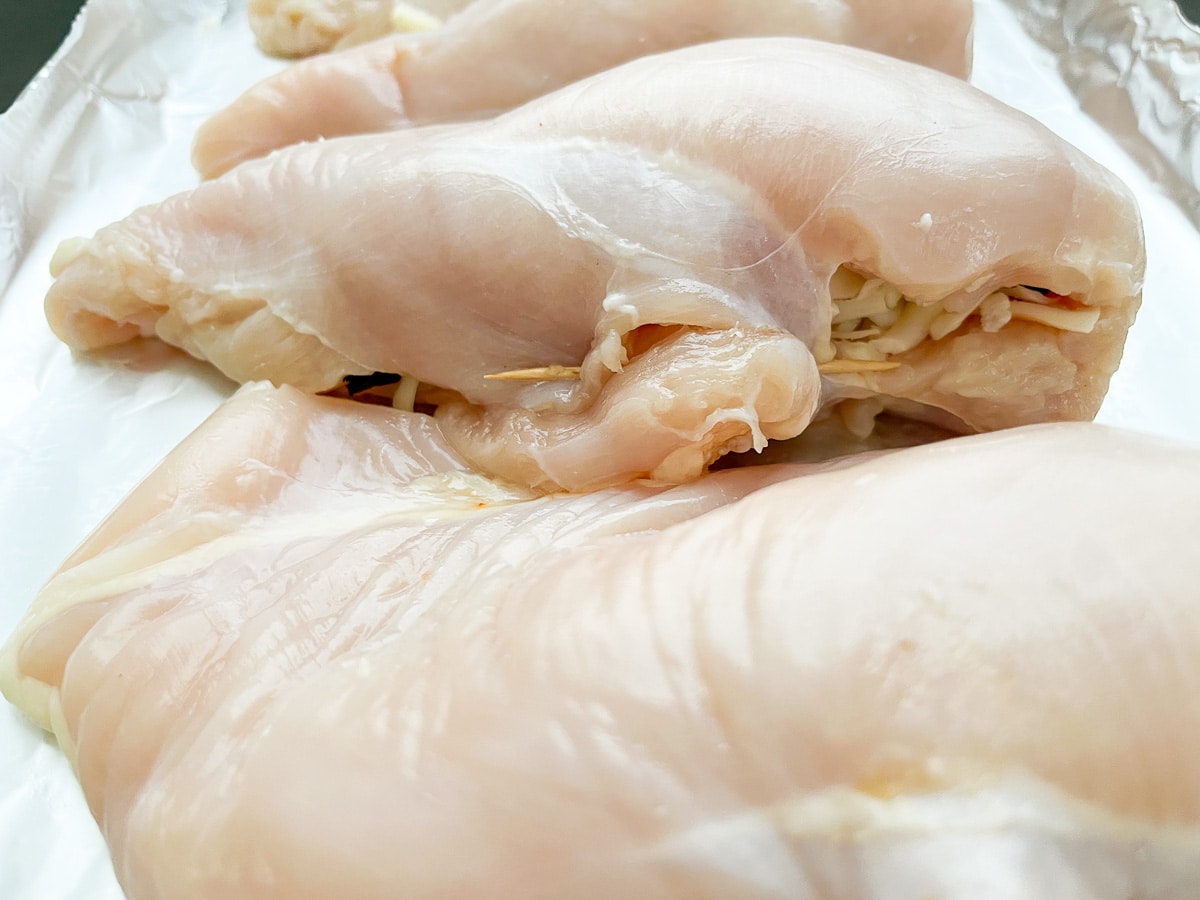 raw chicken breast stuffed with filling.