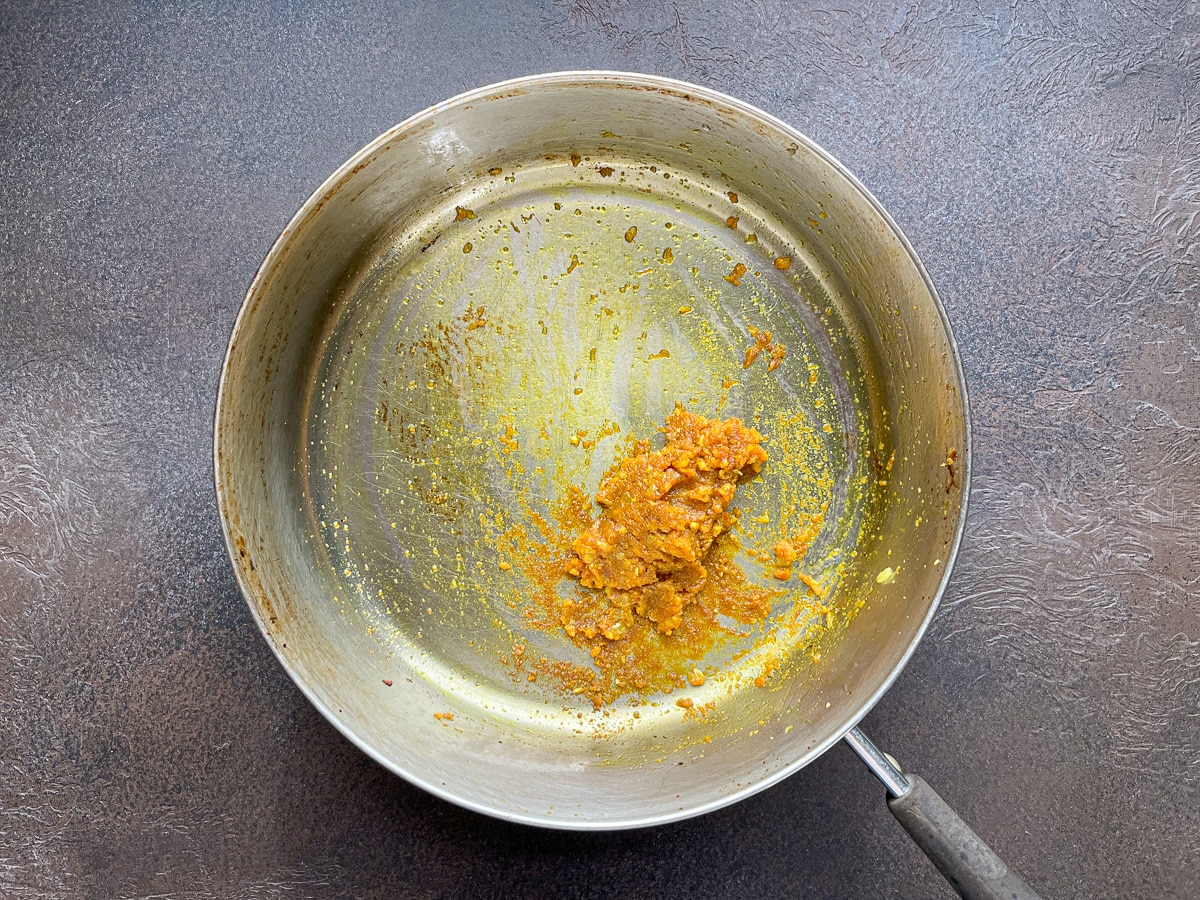 heating turmeric, other seasonings, and aromatics in saucepan.