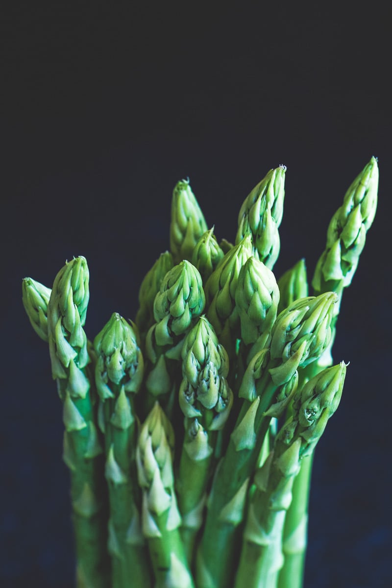 asparagus in an upright position against a dark background.