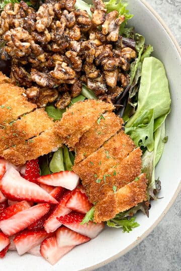 close-up of ingredients in white bowl before salad is tossed.