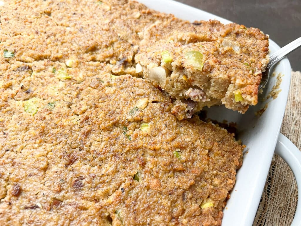 dressing in a white casserole dish with a piece cut to serve.