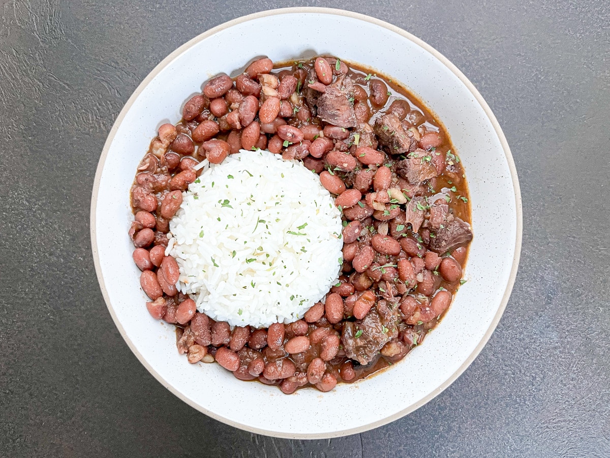 An overhead shot of a white bowl of Cajun red beans and rice.