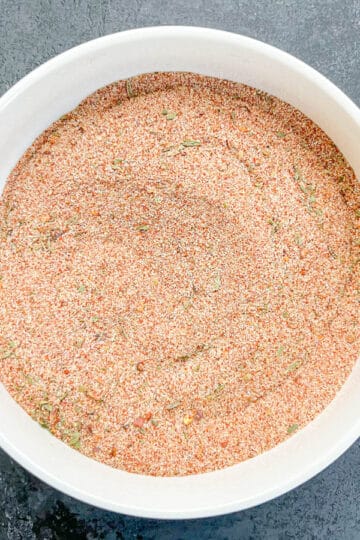 Cajun seasoning ingredients are all combined in a white bowl.