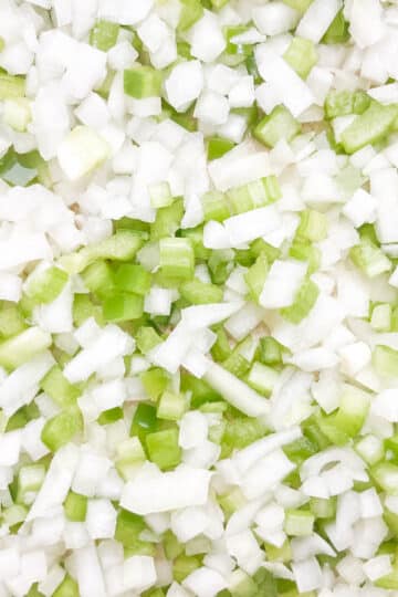 Close-up shot of diced onion, green bell pepper, and celery.