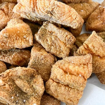 Close-up image of golden, crispy Southern fried fish in a bowl lined with parchment paper, ready to serve.