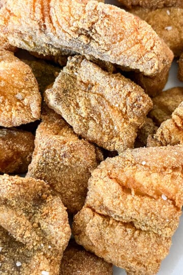 Close-up image of golden, crispy Southern fried fish in a bowl lined with parchment paper, ready to serve.