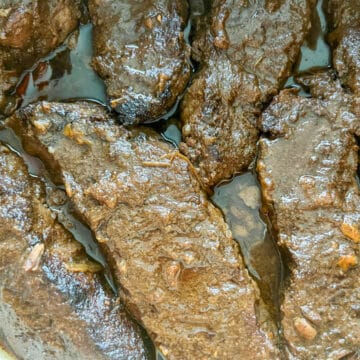 Braised boneless beef chuck short ribs in a Dutch oven with bell peppers and onions, cooked in the oven until fork-tender.